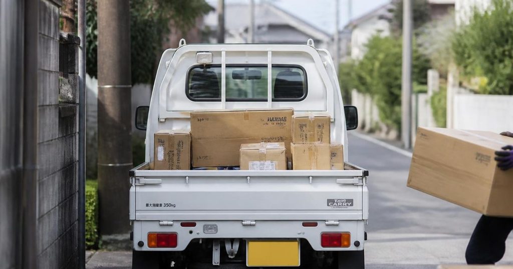 荷台に段ボールを積んだ軽トラの後ろ姿